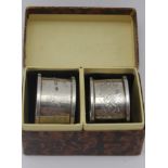 JOSEPH GLOSTER LTD A pair of silver napkin rings, floral chased decoration, Birmingham 1913, in a