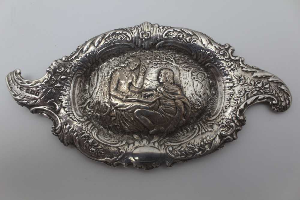 AN EARLY 20TH CENTURY TWO HANDLED SILVER PIN TRAY, cast with a central scene of a couple wearing