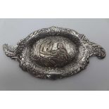 AN EARLY 20TH CENTURY TWO HANDLED SILVER PIN TRAY, cast with a central scene of a couple wearing