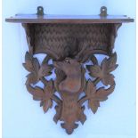 A LATE 19TH / EARLY 20TH CENTURY PROBABLE SWISS CARVED WOODEN WALL BRACKET decorated with a deer