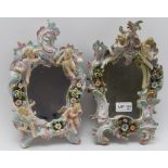 A PAIR OF SITZENDORF PORCELAIN WALL MIRRORS, scroll fork frames, floral encrusted and cherub
