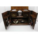 AN EDWARDIAN OAK SMOKER'S CABINET, hinged lid and two doors to front, fitted brass side carrying