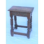 AN OAK JOYNT STOOL, carved frieze on fluted supports & plain stretchers, considered to be late