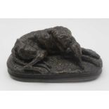 A BRONZE EFFECTC RESIN RECLINING HOUND after Cayrard, 14.5cm