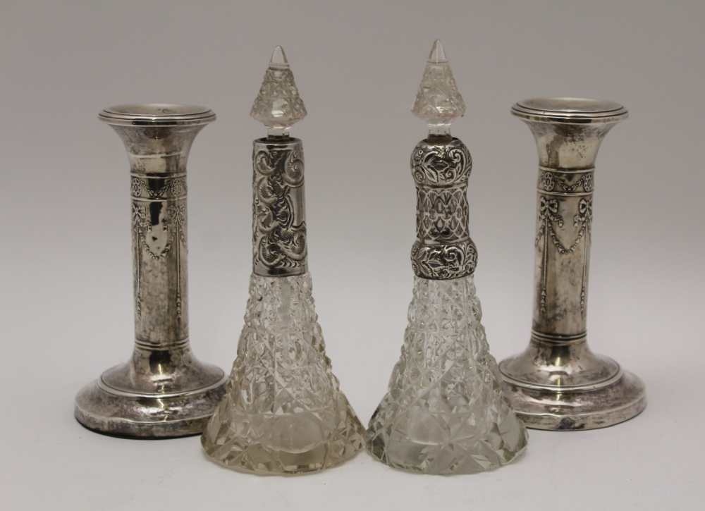 A PAIR OF EDWARDIAN SILVER CANDLESTICKS, embossed ribbon and bell husk swags on circular bases,