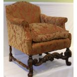 A FANCY CARVED WOODEN SHOW FRAMED LOW BACKED ARM CHAIR all-over upholstered in red & gold
