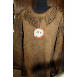 A NATIVE AMERICAN BUCK SKIN PULL OVER SHIRT, with fringe and beadwork, owl mask to the chest,