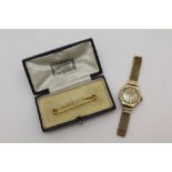 A 9CT GOLD STOCK PIN IN A 'HARRODS, LONDON' BOX, together with a 9ct gold lady's cocktail watch,