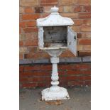 A CAST METAL FRONT GARDEN PEDESTAL LETTER BOX the front panel featuring a huntsman on his horse, the