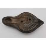 A ROMAN STONEWARE OIL LAMP possibly from North Africa, cast with a Pegasus horse decoration, 10.5cm