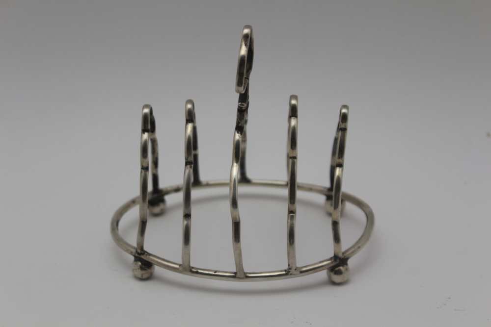 A LATE VICTORIAN SILVER TOAST RACK, oval base raised on four ball feet, Birmingham 1898, 11cm, 66g