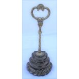 A VICTORIAN DOOR PORTER, brass handle on an iron base, 28cm high