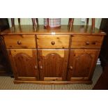 A MODERN PINE SIDEBOARD / DRESSER BASE with three inline drawers over three panelled cupboard doors