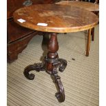 A MAHOGANY CIRCULAR TOPPED TABLE on turned column & three carved & scrolling legs