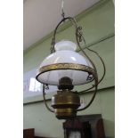 A HANGING BRASS RESERVOIRED OIL LAMP, later converted to electricity, with plain chimney and milk