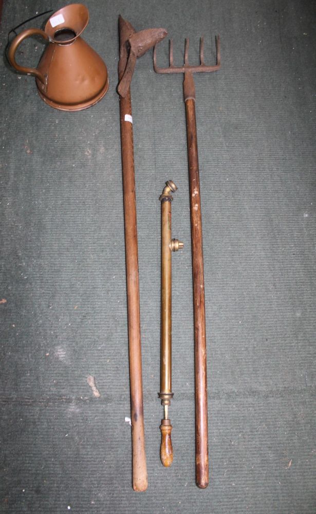 A COPPER MEASURE together with a plant sprayer, a wooden shafted rake, and a wooden shafted planter