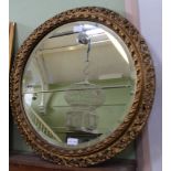 A FANCY PIERCED GILT CIRCULAR FRAMED BEVEL PLATE WALL MIRROR