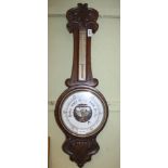 AN EARLY 20TH CENTURY CARVED OAK BACKED BAROMETER/THERMOMETER