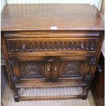 A GOOD QUALITY REPRODUCTION OAK FINISHED SIDE UNIT fitted carved front full width drawer, over two