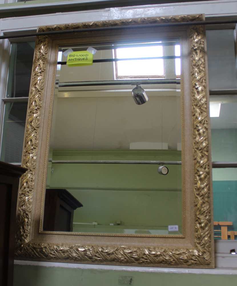 A LARGE RECTANGULAR BEVEL PLATE WALL MIRROR in fancy gilt frame, with leaf and berry pattern