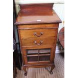 A MAHOGANY FINISHED MUSIC CABINET with two drawers over bar glazed cupboard door, supported on short