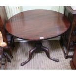 A 19TH CENTURY MAHOGANY CIRCULAR TILT TOP TABLE on turned column and three outswept legs