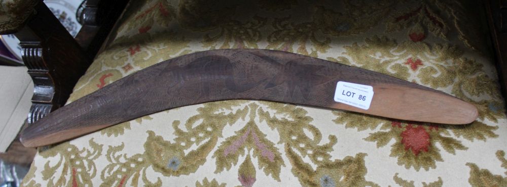 A CARVED WOODEN BOOMERANG decorated with a kangaroo