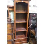 A MAHOGANY FINISHED IMPORTED HARDWOOD SET OF OPEN SHELVES the base having a single drawer