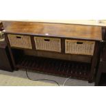 A MAHOGANY FINISHED IMPORTED HARDWOOD SIDE UNIT, having three inline woven bamboo drawers, supported
