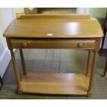 AN ERCOL SIDE TABLE fitted with a single full width drawer, supported on plain turned legs, with a