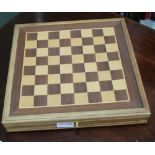 A SMALL WOODEN CHESS BOARD CONTAINING CHESS / DRAFTS PIECES