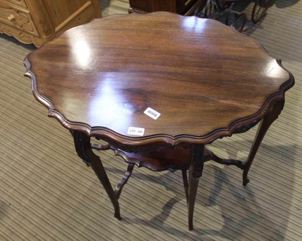 A MAHOGANY FINISHED INVERT PIECRUST EDGE FANCY SHAPED OCCASIONAL TABLE supported on six slender