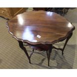 A MAHOGANY FINISHED INVERT PIECRUST EDGE FANCY SHAPED OCCASIONAL TABLE supported on six slender