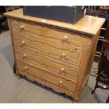 A PINE CARVED FRONTED FOUR DRAWER CHEST, in the Continental manner