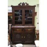 A LATE 19TH / EARLY 20TH CENTURY OAK FINISHED BOOKCASE UNIT with fancy carved pediment, over two