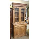 A 19TH CENTURY PINE BOOKCASE UNIT with plain cornice, over two plain & glazed cupboard doors,
