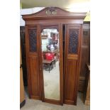 A LATE 19TH / EARLY 20TH CENTURY WALNUT WARDROBE having bevel mirrored insert central door,