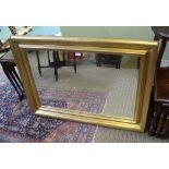 A LARGE PLAIN RECTANGULAR PLATE MIRROR, in fancy gilt frame