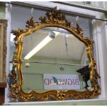 A FANCY SHAPED PLAIN PLATE WALL MIRROR in floral moulded gilt frame