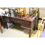 A MAHOGANY FINISHED IMPORTED HARDWOOD DESK of plain rectangular form, with five drawers