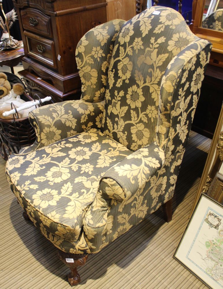 A GEORGIAN DESIGN DEEP SEATED WINGBACK ARMCHAIR, in old gold floral flock upholstery, with fancy