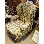 A GEORGIAN DESIGN DEEP SEATED WINGBACK ARMCHAIR, in old gold floral flock upholstery, with fancy