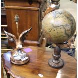 A REPRODUCTION TABLE GLOBE together with a table lamp, in the form of a spread eagle