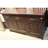 A MAHOGANY COLOURED IMPORTED HARDWOOD SIDEBOARD UNIT having plain rectangular top, with three inline
