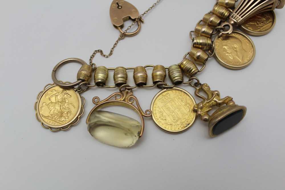 A YELLOW METAL CHARM BRACELET set with four framed full sovereigns, and five fob seals, some - Image 3 of 4