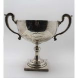 ADIE BROTHERS LTD. A SILVER HANDLED TROPHY CUP, raised on kop stem and square platform base,