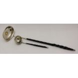 A GEORGE III WHITE METAL LADLE, the bowl inset a coin dated 1808, fitted a twisted whalebone handle,
