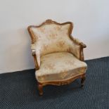 A reproduction French style lounge chair with beige floral upholstery. IMPORTANT: Online viewing and