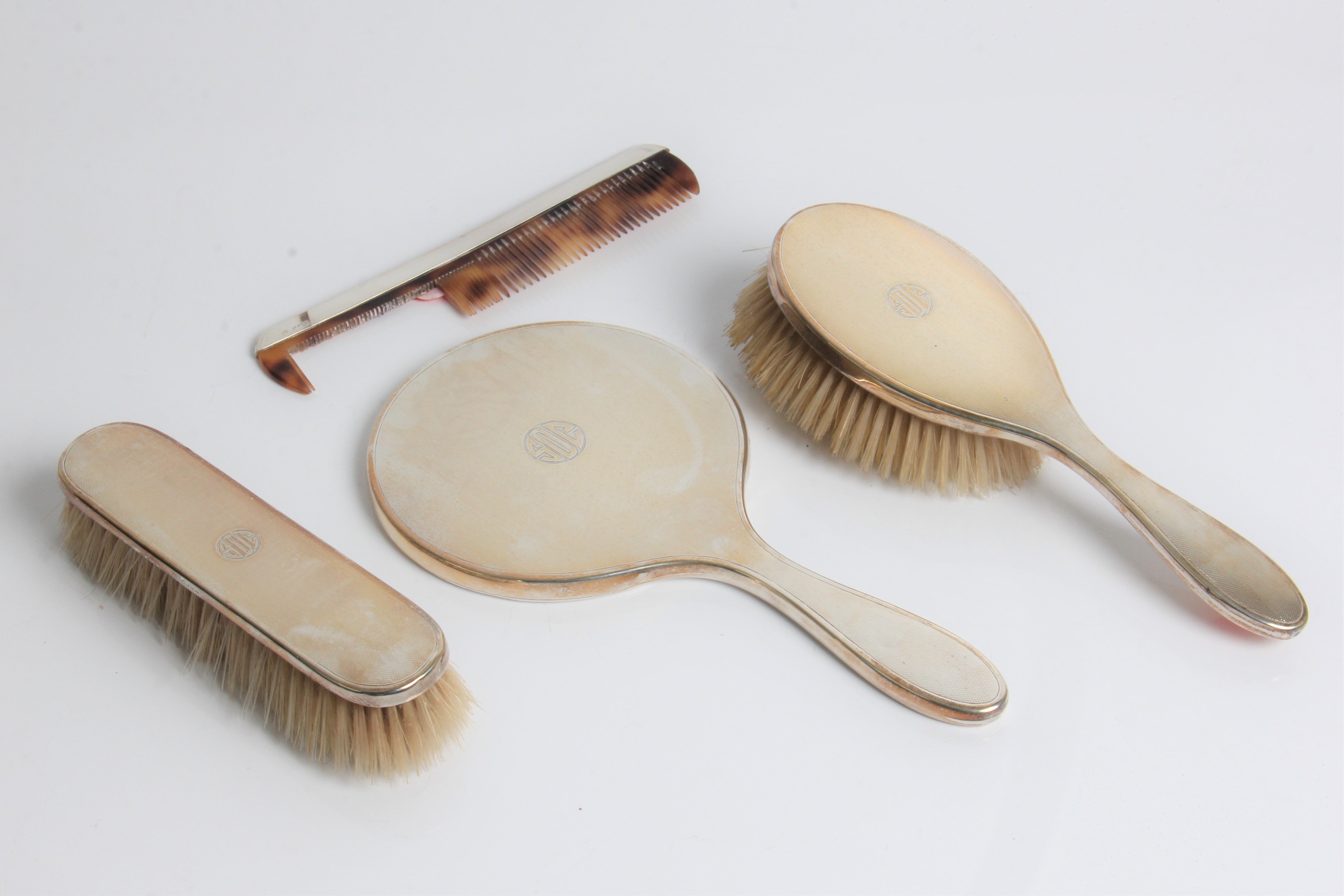 A silver brush set including hairbrush, comb and mirror, with marks for London 1951 and Carrington &