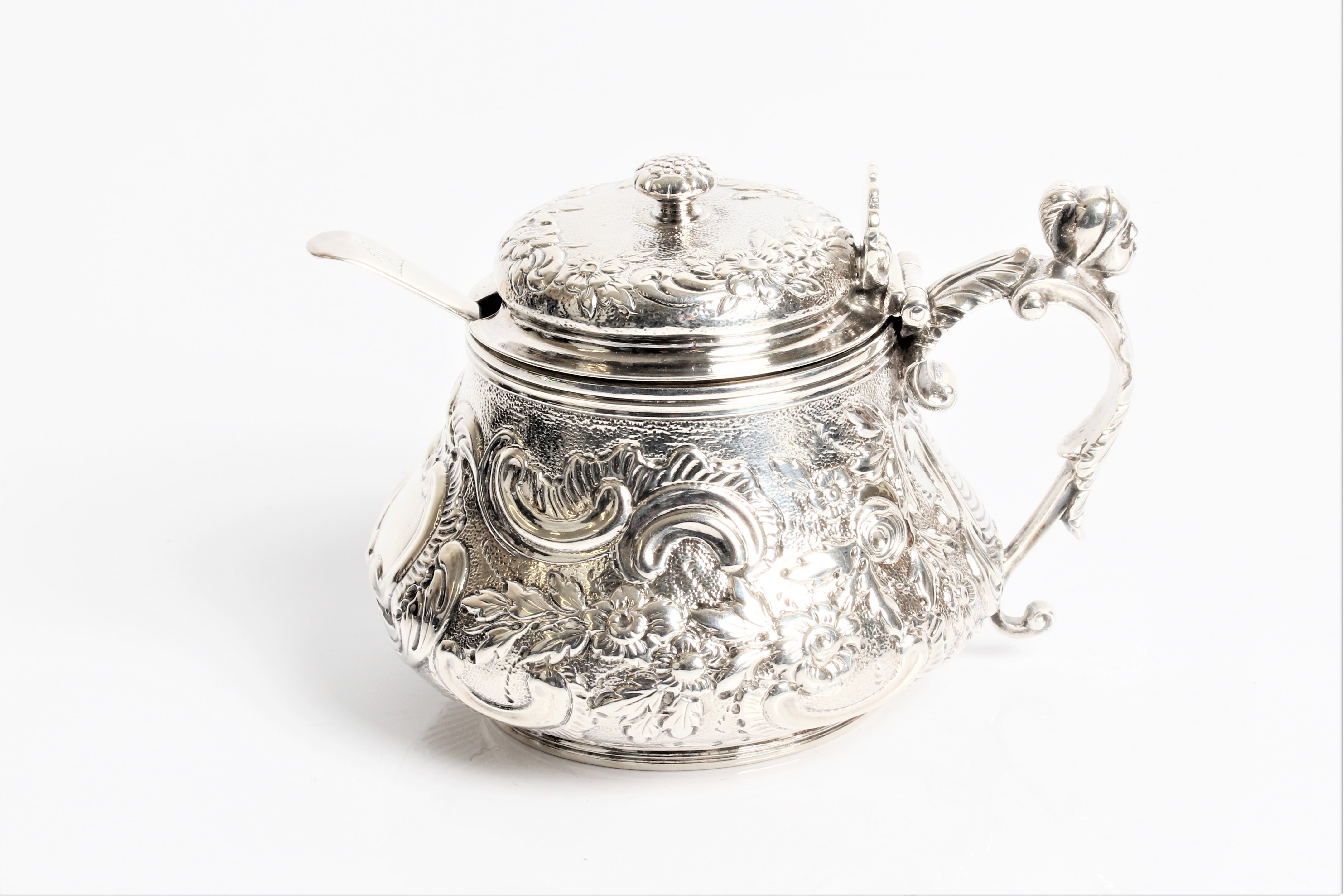 A George III silver mustard with decorative swags and head of a soldier to handle with marks for